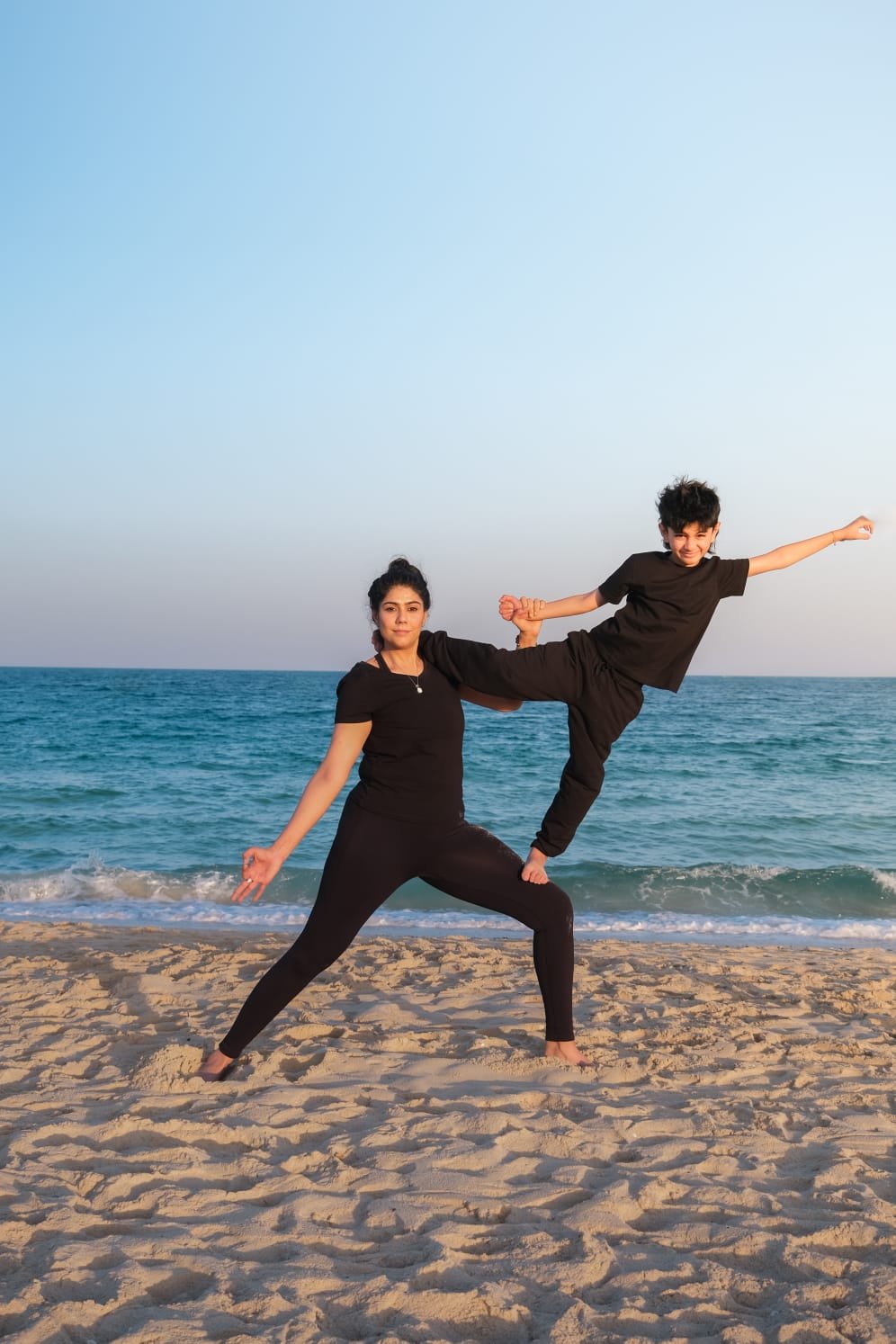 Kids practising yoga on the beach